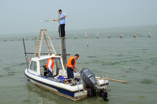 researchers on a small powerboat